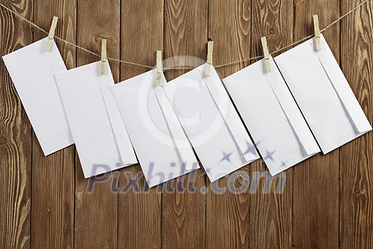 Envelopes hanging on rope on wooden background Envelopes hanging on rope on wooden background
