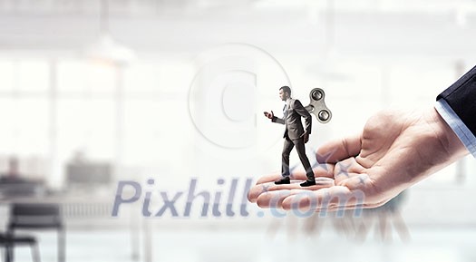Walking businessman with wind-up key on his back. Mixed media Walking businessman with wind-up key on his back. Mixed media