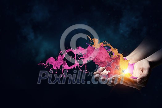 Close up of hand holding splashes of colorful paint Close up of hand holding splashes of colorful paint