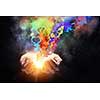 Close up of hand holding splashes of colorful paint