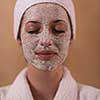 Spa Woman applying Facial Mask  Beauty Treatments  Close up portrait of beautiful girl with a towel on her head applying facial mask