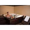 young handsome man enjoys relaxing in the jacuzzi with candles and champagne at luxury resort spa