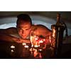 young handsome man enjoys relaxing in the jacuzzi with candles and champagne at luxury resort spa
