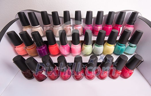 Set of different bottles of nail polish in the shelf in the beauty salon Set of different bottles of nail polish in the shelf in the beauty salon
