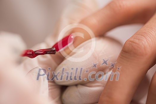 Woman hands receiving a manicure in beauty salon. Nail filing. Close up, selective focus. Woman hands receiving a manicure in beauty salon. Nail filing. Close up, selective focus.