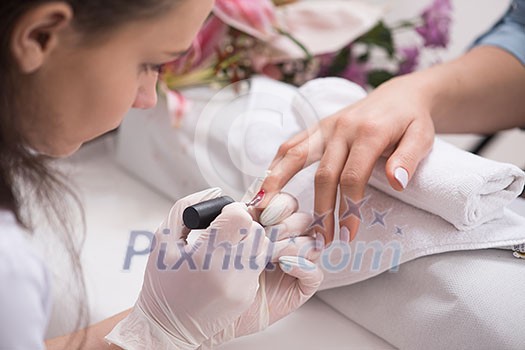 Woman hands receiving a manicure in beauty salon. Nail filing. Close up, selective focus. Woman hands receiving a manicure in beauty salon. Nail filing. Close up, selective focus.
