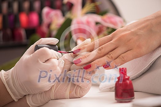 Woman hands receiving a manicure in beauty salon. Nail filing. Close up, selective focus. Woman hands receiving a manicure in beauty salon. Nail filing. Close up, selective focus.