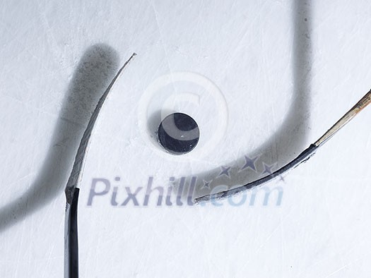 two hockey sticsk and puck on ice, start of the game, competition concept in business, top view two hockey sticsk and puck on ice, start of the game, competition concept in business, top view