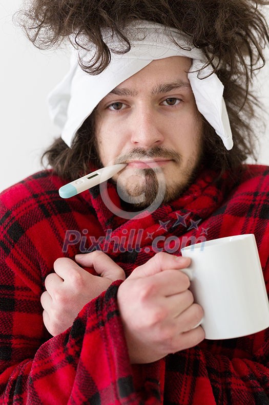 young Man with flu and fever wrapped holding cup of healing tea isolated over white young Man with flu and fever wrapped holding cup of healing tea isolated over white