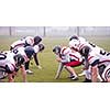 group of young professional american football players ready to start during training match on the stadium field