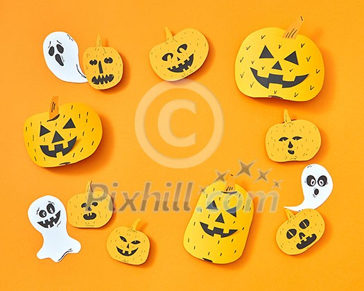 Flying paper ghosts and handcraft pumpkins in the shape of a square frame on an orange background with space for text. Layout for postcard to halloween Flying paper ghosts and handcraft pumpkins in the shape of a square frame on an orange background with space for text. Layout for postcard to halloween