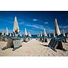 Scenic Sardinia island landscape. Italy sea ​​coast with azure clear water. Beach with umbrellas and loungers ready for the high season to start