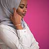 young afro beauty wearing traditional islamic clothes on plastic pink background