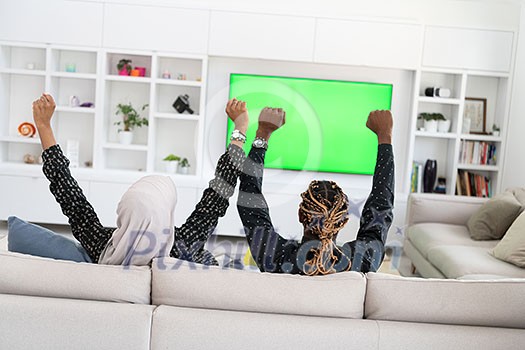African Couple Sitting On Sofa Watching TV Together Chroma Green Screen Woman Wearing Islamic Hijab Clothes African Couple Sitting On Sofa Watching TV Together Chroma Green Screen Woman Wearing Islamic Hijab Clothes