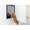 close up of hand of African woman using smart home screen control system