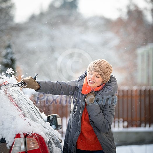 Pretty, young woman cleaning her car from snow after heavy snowstorm (color toned image) Pretty, young woman cleaning her car from snow after heavy snowstorm (color toned image)