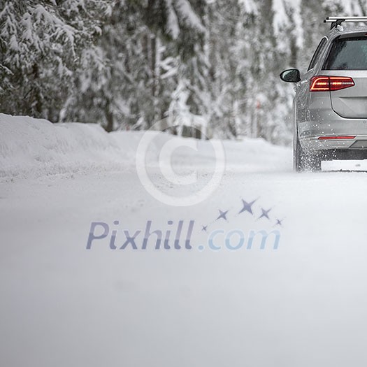 Car on a snowy winter road amid forests - using its four wheel drive capacities to get through the snow Car on a snowy winter road amid forests - using its four wheel drive capacities to get through the snow