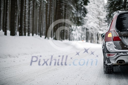 Car on a snowy winter road amid forests - using its four wheel drive capacities to get through the snow Car on a snowy winter road amid forests - using its four wheel drive capacities to get through the snow