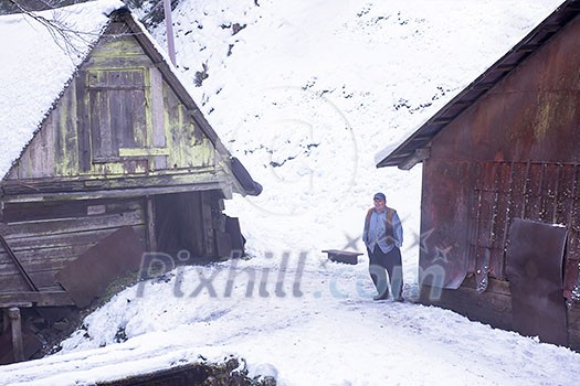 portrait of confident traditional senior blacksmith worker standing in front of old watermill at winter time portrait of confident traditional senior blacksmith worker standing in front of old watermill at winter time