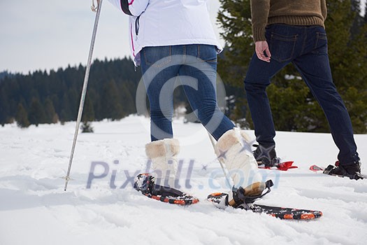 happy young couple having fun and walking in snow shoes outdoor in nature at beautiful winter day. Health sport and relaxation happy young couple having fun and walking in snow shoes outdoor in nature at beautiful winter day. Health sport and relaxation