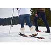 happy young  couple having fun and walking in snow shoes outdoor in nature at beautiful winter day. Health sport and relaxation