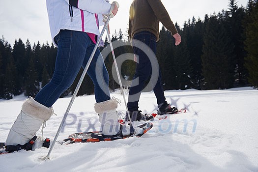 happy young couple having fun and walking in snow shoes outdoor in nature at beautiful winter day. Health sport and relaxation happy young couple having fun and walking in snow shoes outdoor in nature at beautiful winter day. Health sport and relaxation