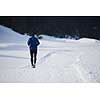 young  man jogging on snow in forest, bautiful sunny winter day. handsome sporty ahtlete man running