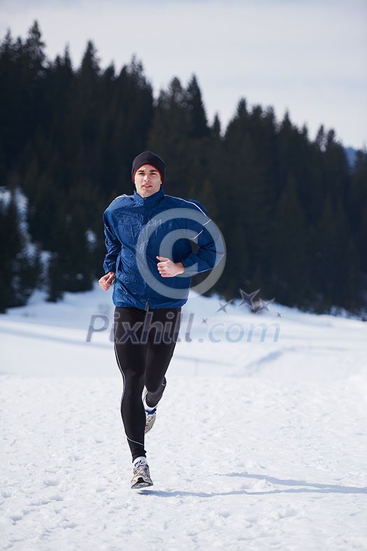 young man jogging on snow in forest, bautiful sunny winter day. handsome sporty ahtlete man running young man jogging on snow in forest, bautiful sunny winter day. handsome sporty ahtlete man running