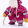 happy cute little girl wearing a red snow suit and white hat  while having fun and playing on fresh snow at snowy winter day