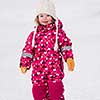happy cute little girl wearing a red snow suit and white hat  while having fun and playing on fresh snow at snowy winter day