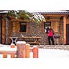 young man cooking meat on barbecue in front of the weekend house on a cold winter day