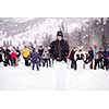 group of young happy business people having a running in bag competition while enjoying snowy winter day with snowflakes around them during a team building in the mountain forest