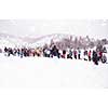 group of young happy business people having a running in bag competition while enjoying snowy winter day with snowflakes around them during a team building in the mountain forest