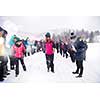 group of young happy business people having a Blindfolded games competition while enjoying snowy winter day with snowflakes around them during a team building in the mountain forest