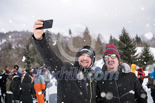 group of young happy business people taking a selfie while having fun on snowy winter day with snowflakes around them during a team building in the mountain forest group of young happy business people taking a selfie while having fun on snowy winter day with snowflakes around them during a team building in the mountain forest