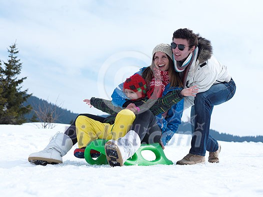 Winter playing, fun, snow and family portrait sledding at winter time Winter playing, fun, snow and family portrait sledding at winter time