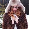 portrait of beautiful young redhair woman in snow scenery with warm hat