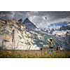 Pretty, female climber on a via ferrata - climbing on a rock in Swiss Alps