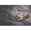 Pretty, middle-aged woman sleeping in her bed at home, having a good night rest in a comfortable bed