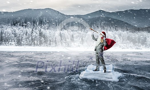 Businessman in Santa hat looking in spyglass. Mixed media Businessman in Santa hat looking in spyglass. Mixed media