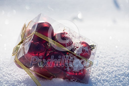 christmas ball in box on fresh snow at beautiful sunny winter day christmas ball in box on fresh snow at beautiful sunny winter day
