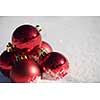 christmas red balls decoration in fresh snow background on beautiful sunny winter day