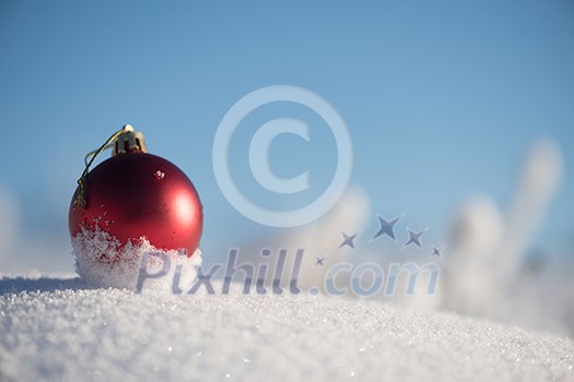 christmas red balls with long shadows  in fresh snow on beautiful sunny winter day