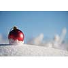 christmas red balls with long shadows  in fresh snow on beautiful sunny winter day