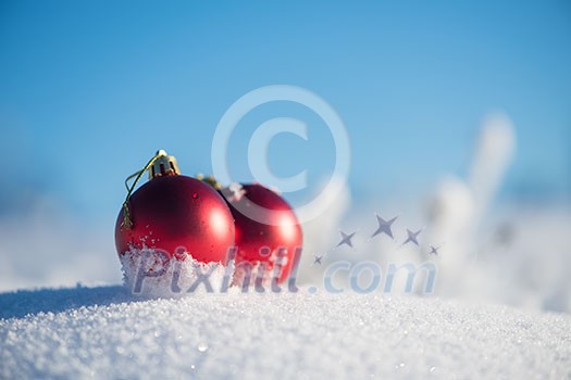 christmas red balls with long shadows in fresh snow on beautiful sunny winter day christmas red balls with long shadows in fresh snow on beautiful sunny winter day