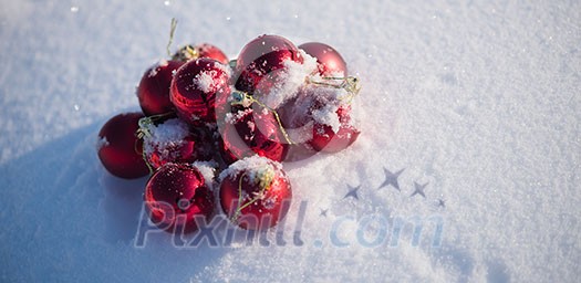 christmas red balls with long shadows in fresh snow on beautiful sunny winter day christmas red balls with long shadows in fresh snow on beautiful sunny winter day
