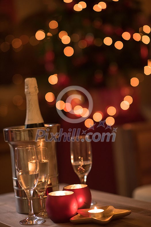 champagne and crystal glasses on a wooden table with candles and holiday lights in the background champagne and crystal glasses on a wooden table with candles and holiday lights in the background