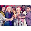 multiethnic group of young happy casual business people lighting a sparkler and having fun while celebrating new year eve in front of concrete wall at new startup office