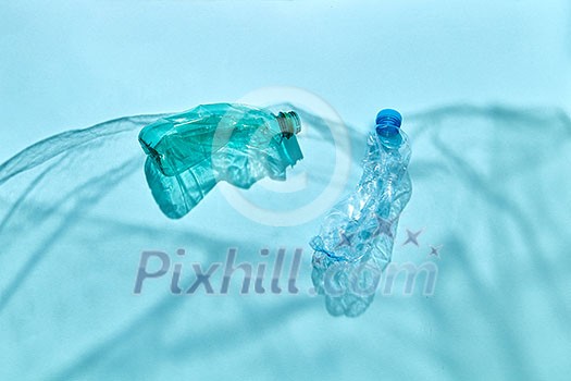 Ocean waves from shadows of polyethylene foil with floating bottles underwater on a pastel blue background, copy space. Concept of enviromental pollution of world ocean. Ocean waves from shadows of polyethylene foil with floating bottles underwater on a pastel blue background, copy space. Concept of enviromental pollution of world ocean.