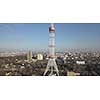 TV tower on the background of the modern city around a blue sky on a sunny day. 4K video, 240fps, 2160p.